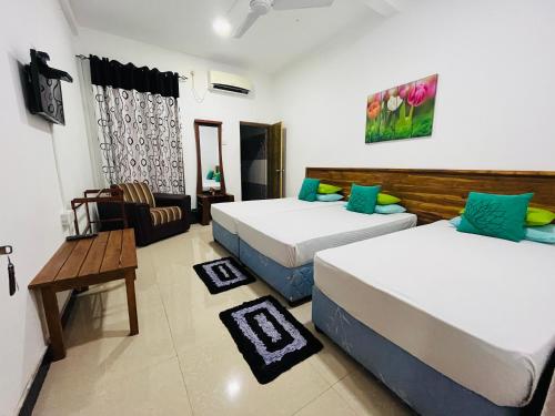 波隆纳鲁沃提山度假酒店的酒店客房设有两张床和一张桌子。