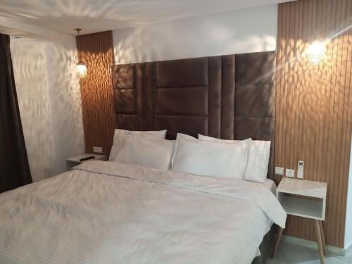 非斯Nouvel appartement climatisé的卧室配有一张白色大床和木制床头板