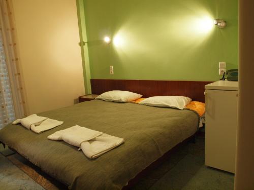 卡梅纳维洛拉Noufara Hotel的一间卧室配有带毛巾的床