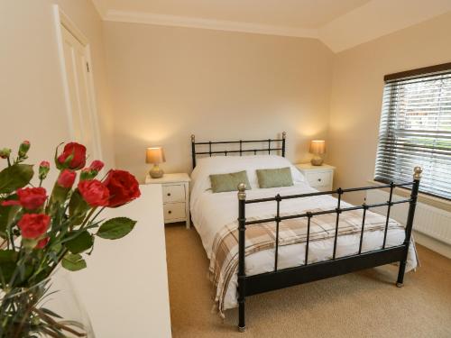 考斯Seagulls Perch的一间卧室,配有一张床和一束红玫瑰花