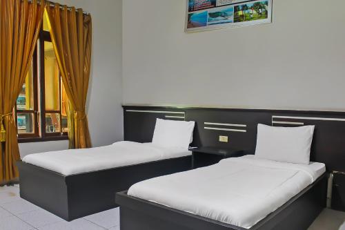 NegarasakaCollection O 92268 Hotel Aero的两张睡床彼此相邻,位于一个房间里