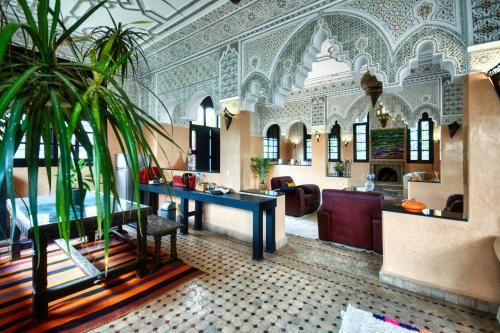 阿加迪尔Dafa Splendide Riad Agadir résidentiel 8 or 9 Px的酒店大堂设有桌子和棕榈树