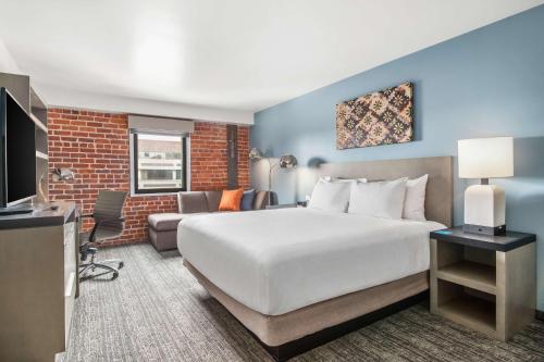 萨克拉门托Hyatt House Sacramento-Midtown的酒店客房设有一张大床和一张沙发。