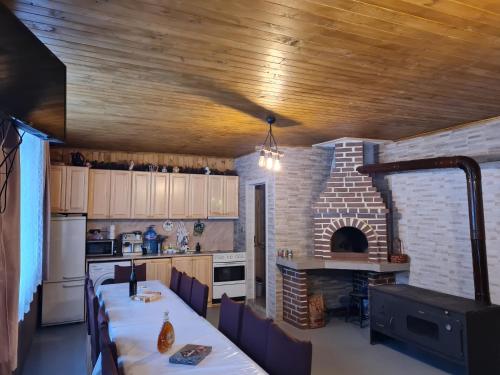 巴塔克Вила Вайлин的厨房配有长桌和砖炉