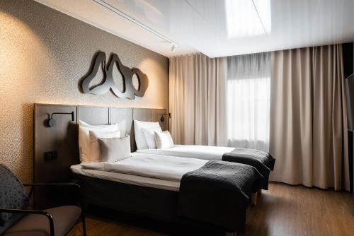库奥皮奥普伊乔恩萨维所库斯原始酒店的酒店客房设有两张床和窗户。