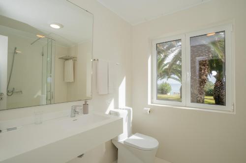 圣港Dune Beach CoLiving的白色的浴室设有卫生间和窗户。
