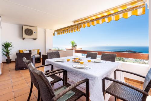 林孔-德拉维多利亚Ceres Malaga Apartamento de Lujo的一间带桌椅的海景用餐室