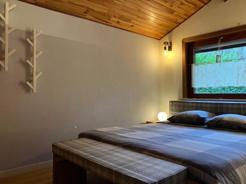 Gîte L'Orée的一间卧室设有一张床和一个窗口