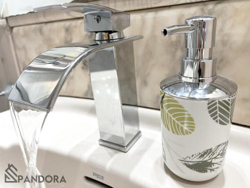 耶克拉Apartamento Pandora的浴室盥洗盆和柜台上的肥皂分配器