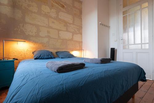 波尔多Maison spacieuse avec Jardin et Garage的一间卧室配有一张带蓝色床单和枕头的床。