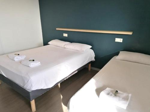 勒芒勒芒艾克洛酒店的小型客房 - 带两张床和绿色墙壁
