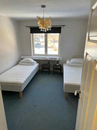 博伦厄Lärkan 21 Tvisegatan 24的客房设有两张床、一个窗户和一个吊灯。