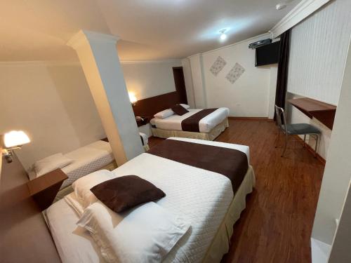 安巴托Gran Hotel Napoleón的酒店客房配有两张床和一张书桌