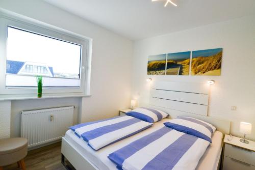 库克斯港Am Sahlenburger Strand AS01的一间白色卧室,配有两张床和窗户