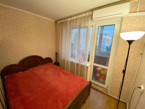 尼古拉耶夫Центр 3 слободская的一间卧室设有红色的床和窗户。