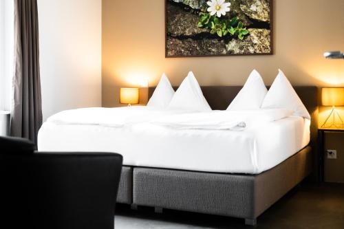 韦吉斯Alpenblick Weggis - Panorama & Alpen Chic Hotel的酒店客房配有一张带白色枕头的大床