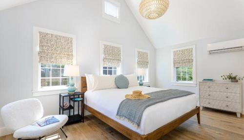 楠塔基特Nantucket Resort Collection的一间卧室配有一张床、一把椅子和窗户。