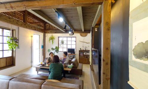 南城ロフトが付いた沖縄古民家で寛ぎの時間を 懐かしくて新しい 海野24的一群人坐在客厅的桌子上