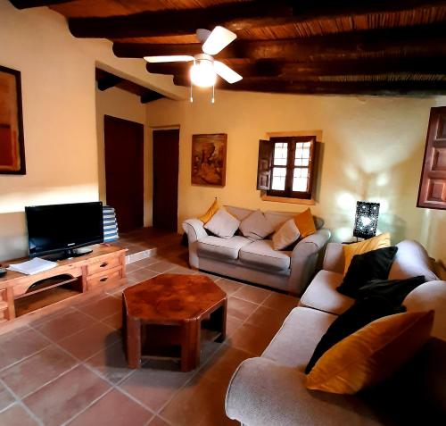 比纽埃拉Los Montes Traditional Casa with private pool的带沙发、电视和桌子的客厅