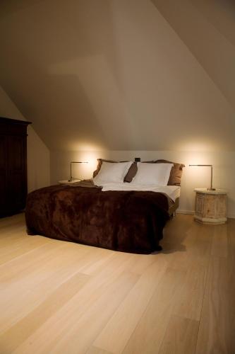 阿纲尔赫姆vakantiehuis ter poele的一间卧室配有一张大床和两盏灯