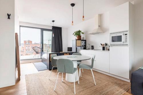 鲁汶New apartment with big terrace and great views!的厨房以及带桌椅的起居室。