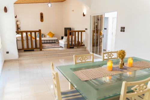 Grand-PopoSpacious and cozy beachfront villa的一间设有玻璃桌和椅子的用餐室