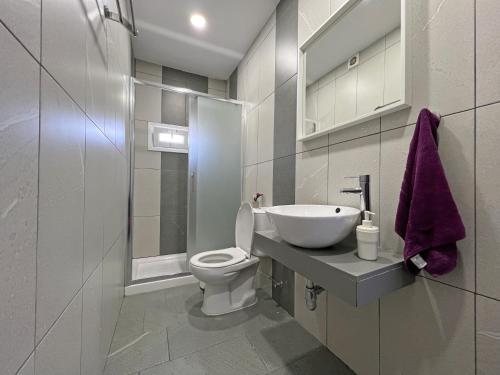 拉纳卡Apollo Rooms by Albert's Apartment的白色的浴室设有卫生间和水槽。
