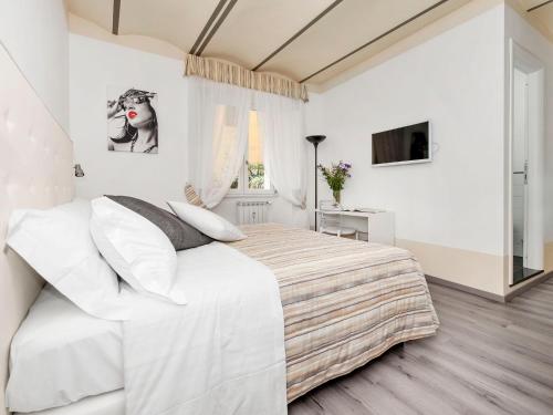 罗马斗兽场白色客房酒店的白色的卧室设有一张大床和一个窗户