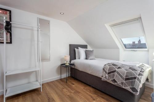 普雷斯蒂克Briarhill - Donnini Apartments的白色的卧室设有床和窗户