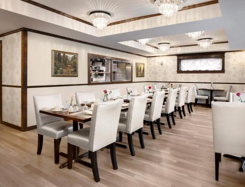维多利亚阿比盖尔酒店 _x000D_的一间带长桌和白色椅子的用餐室