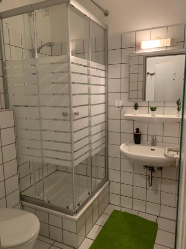 比勒费尔德CityApartment Platinum-Zentrum mit Parkplatz的一间带玻璃淋浴和水槽的浴室