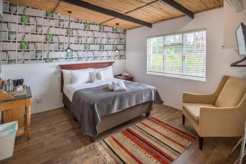 蒙塔古葡萄园乡村住宅酒店的一间卧室配有一张床和一把椅子