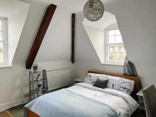 特罗布里奇4 bed loft apartment overlooking historic town的一间卧室设有一张床和两个窗户。