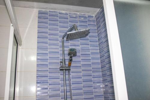 达喀尔DALOU Chambre hôte, Cité mixta的蓝色建筑的房间里设有淋浴