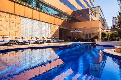 圣地亚哥圣地亚哥万豪酒店 的一座带椅子的游泳池,位于大楼旁