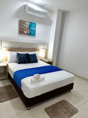 圣玛尔塔Hotel Boutique Deluxe的一间卧室配有一张带蓝白色床单的大床