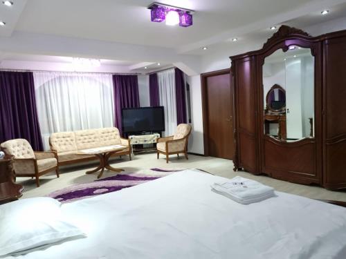 瓦马PENSIUNEA LUXURY的酒店客房设有一张大床和一台电视。