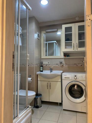伊斯坦布尔塔克西姆公寓式酒店的浴室配有卫生间水槽和洗衣机。