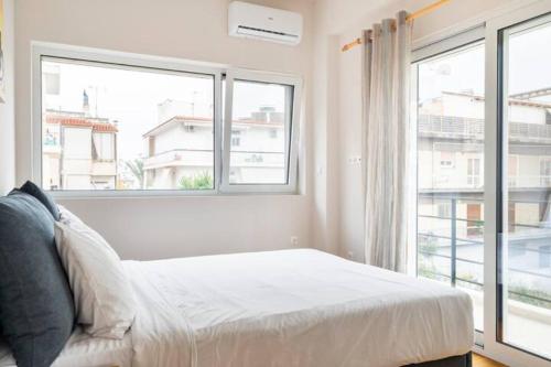 雅典Skiathou 12 Contemporary Residences的一间卧室设有一张床和一个大窗户