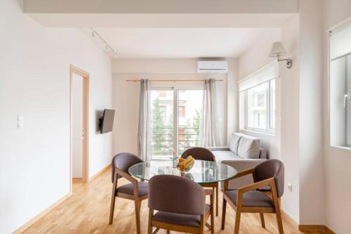 雅典Skiathou 12 Contemporary Residences的客厅配有玻璃桌和椅子
