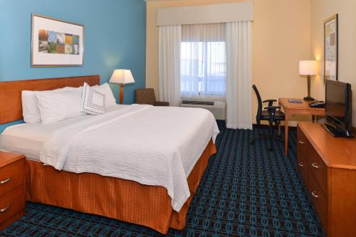 布卢明顿布卢明顿费尔菲尔德套房酒店的酒店客房配有一张床、一张书桌和一台电视。