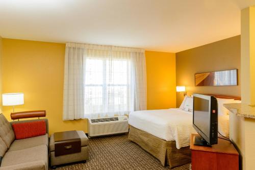 Annapolis JunctionTownePlace Suites by Marriott Fort Meade National Business Park的一间酒店客房,配有一张床和一台电视