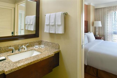 亚特兰大Atlanta Marriott Suites Midtown的一间带水槽、床和镜子的浴室