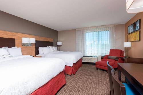曼斯费尔德TownePlace Suites by Marriott Ontario-Mansfield的酒店客房,设有两张床和一张红色椅子