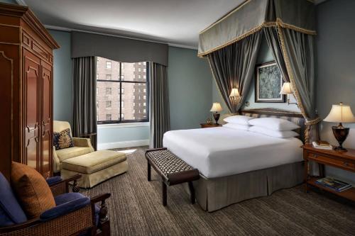 芝加哥布雷克斯通奥图系列酒店的卧室配有一张白色大床和一把椅子
