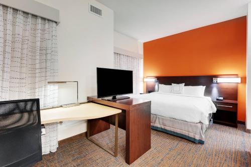 奥斯汀奥斯汀机场原住客栈酒店的酒店客房配有一张床和一张书桌及一台电视