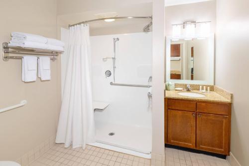 鲍伊鲍威时尚购物中心唐普雷斯套房酒店的带淋浴和盥洗盆的浴室