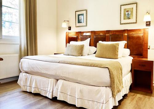 Santa María嘉埃尔温泉酒店及Spa的一间卧室配有一张大床和木制床头板