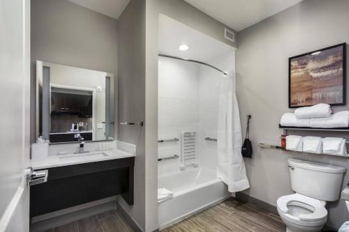 休斯顿TownePlace Suites by Marriott Houston Hobby Airport的带浴缸、卫生间和盥洗盆的浴室