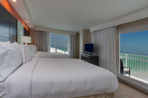代托纳海滩代托纳比奇海滨万豪原住客栈的一间卧室设有一张大床和一个大窗户
